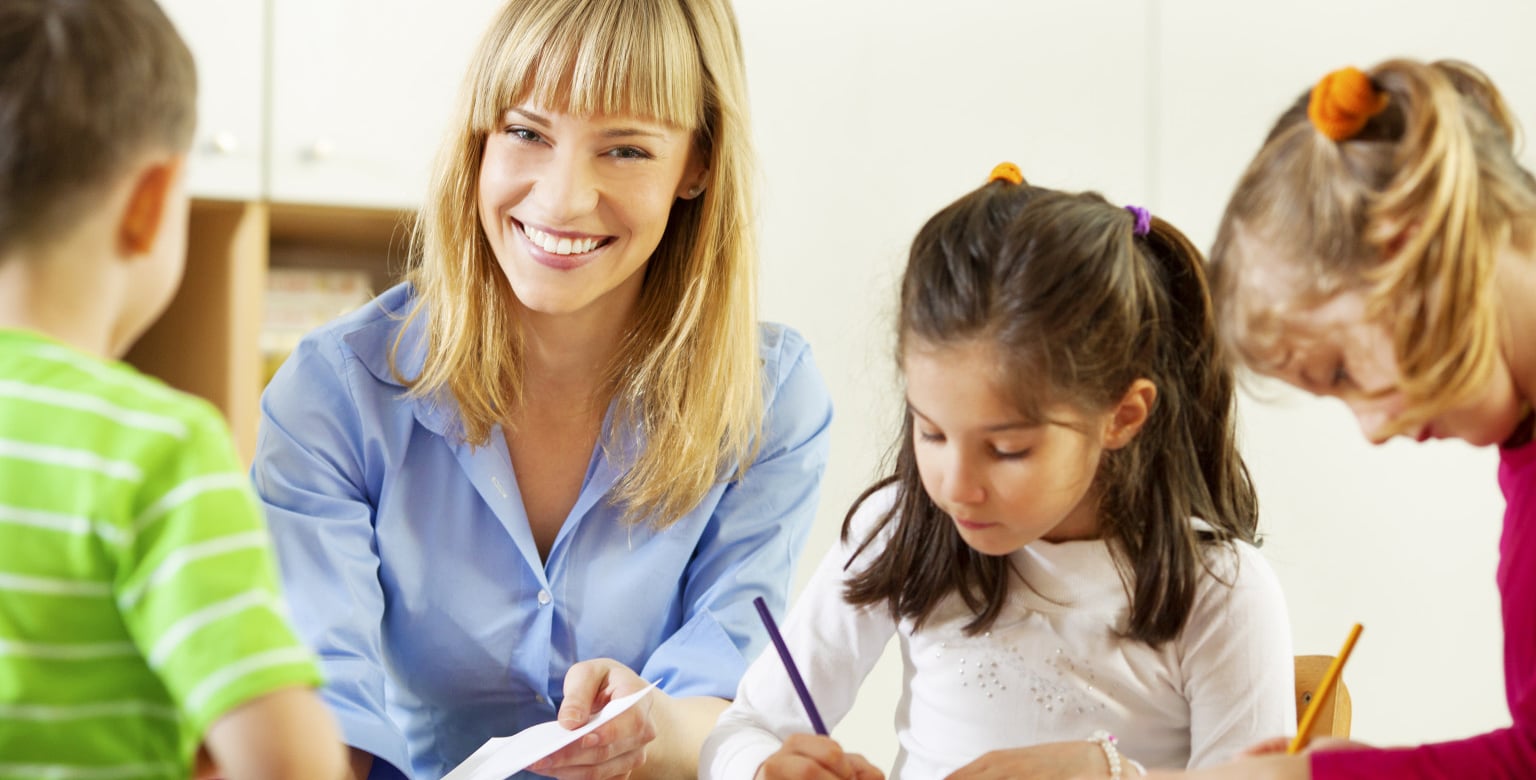 Teacher drawing with children.