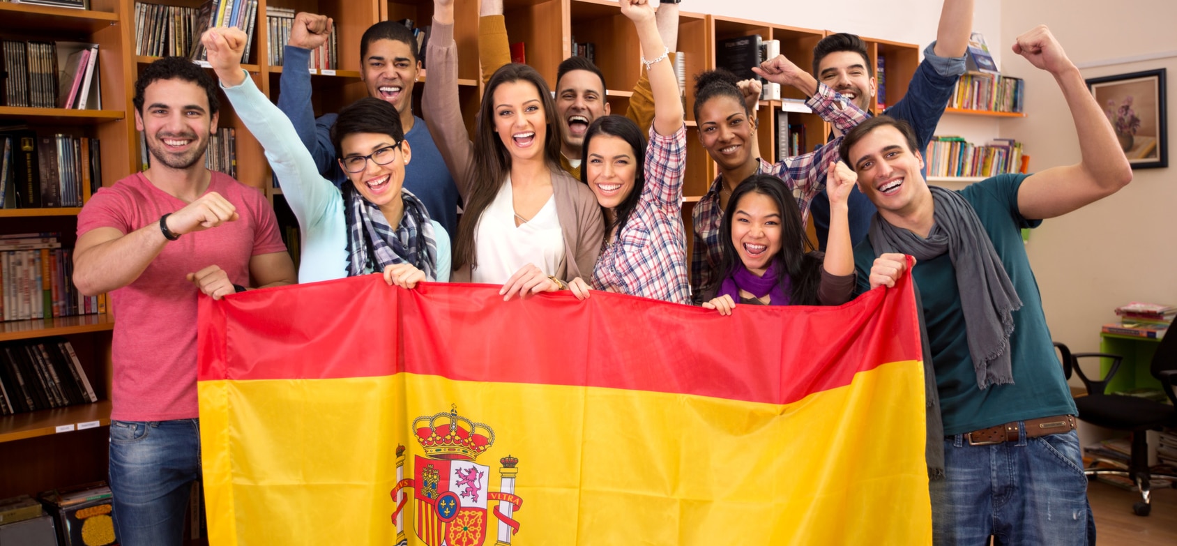 Team of excited Spanish students with victory smile and raised fists