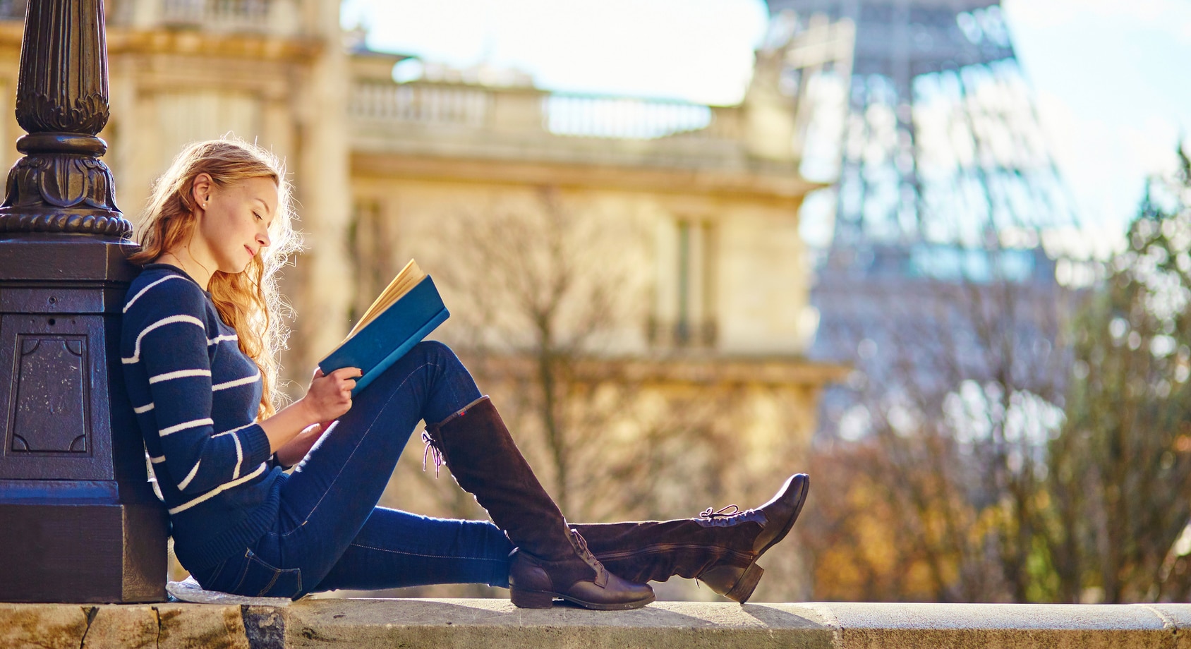Beautiful young woman in Paris, reading a book