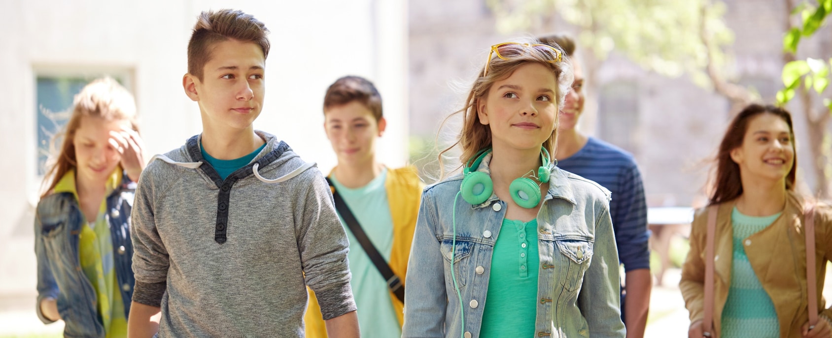 education, high school, communication and people concept - group of happy teenage students walking outdoors